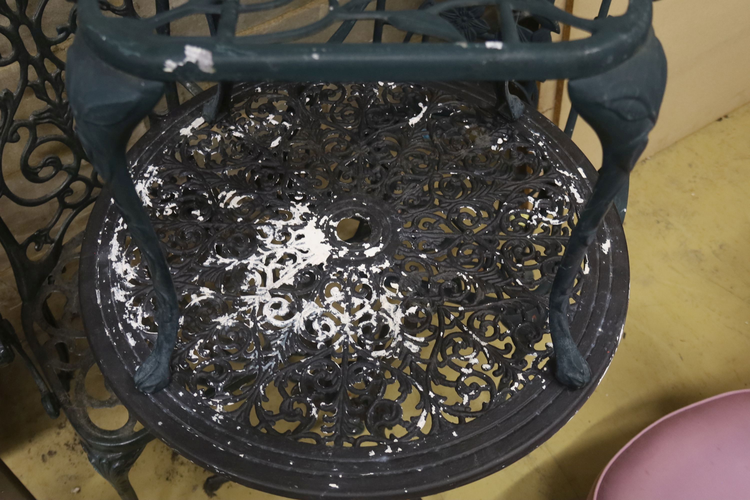 A painted aluminium circular garden table, 69cm diameter together with three chairs